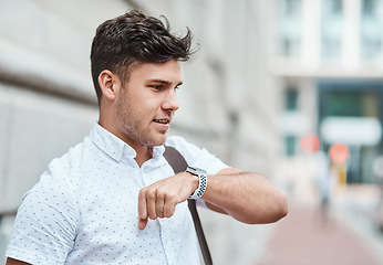 Image showing Chatting on a smartwatch with a young creative business man or intern commuting in the city. Hailing a cab, taxi or ride with an app on wireless technology. Male employee travelling to and from work