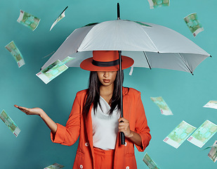 Image showing Money, fashion and rich lady being showered by cash while holding umbrella for insurance, protection and cover showing her wealth after payout. Winning luxury woman with dollar bills in the air