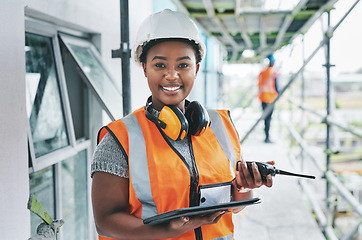 Image showing Portrait of proud black construction worker leading with power while managing site logistics on tablet. Happy female engineer supervising a building project and inspection of architectural details