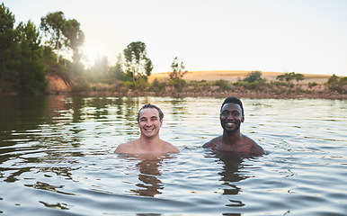 Image showing Vacation, friends and having fun while swimming in a lake and enjoying summer. Portrait of happy and diverse guys smiling while enjoying the water and friendship on their holiday and nature travel