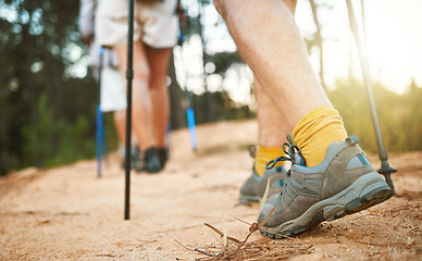 Image showing . Feet or shoes walking, trekking and hiking on a trail up a mountain with sticks and poles. Closeup of group of adventurous hikers or friends exploring rugged path on a mountain in nature.