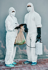 Image showing Scientists disinfect isolated and dangerous area. Medical staff protect themselves with sterile equipment. Healthcare workers clean while wearing safety uniform to stop the spread of a virus.