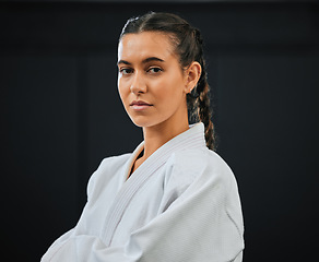 Image showing . Karate, judo or taekwondo woman in white kimono for martial arts, jiu jitsu and kung fu against a black studio background. Portrait of a determined, serious and focused fighter ready for combat.