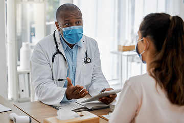 Image showing Doctor appointment by a woman consulting a healthcare or medical worker in an office about covid symptoms. Male African American GP talking to a patient and explaining covid19 regulations