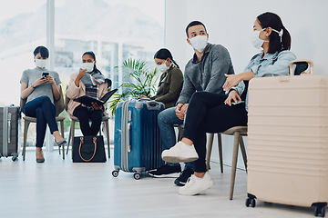 Image showing Group of people traveling during covid waiting in line at an airport lounge wearing protective masks. Tourists sitting in a queue at a public travel facility during coronavirus pandemic