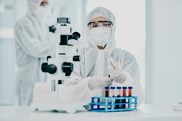 Image showing A scientist conducting a medical experiment to research covid vaccine in a lab and collecting blood samples. Healthcare researcher analyzing chemicals in a chemistry laboratory wearing a hazmat suit