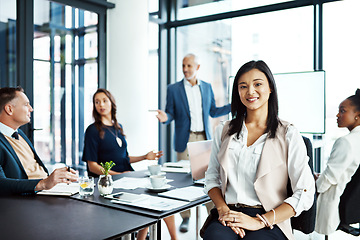 Image showing Businesswoman sitting in a modern boardroom presentation with diverse colleagues. Businesspeople brainstorming in a conference room. Happy, smiling and professional female working with her team.