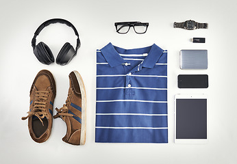 Image showing Flat lay of casual clothes, technology and shoes with a phone, tablet and headphones against background from above. All you need with a watch, USB stick and glasses for creative business workwear