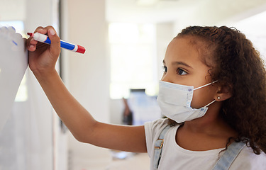 Image showing School student writing on whiteboard in class during covid pandemic for learning, education and study. Young kindergarten, preschool or elementary kid with mask for safety, protection and protocol