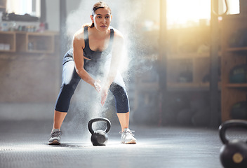 Image showing Fitness kettlebell and gym woman with chalk on hands during weightlifting workout, exercise or training. Athletic, active and strong girl exercising with weight equipment to build muscle strength