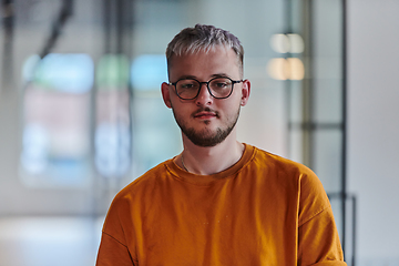 Image showing A modern portrait captures a blue-haired businessman wearing glasses, exuding creativity and professionalism, within the ambiance of a startup coworking office