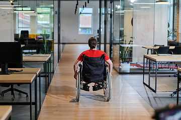 Image showing A modern young businesswoman in a wheelchair is surrounded by an inclusive workspace with glass-walled offices, embodying determination and innovation in the business world