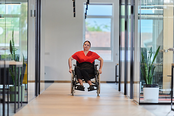 Image showing A modern young businesswoman in a wheelchair is surrounded by an inclusive workspace with glass-walled offices, embodying determination and innovation in the business world