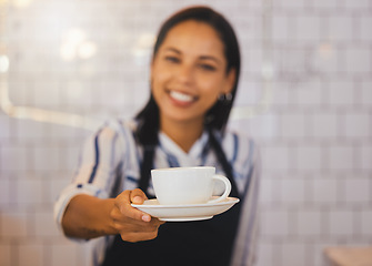 Image showing Small business owner, barista manager or waitress in coffee shop, cafe or retail shop with friendly smile and customer service. Restaurant cashier hands cup of coffee, tea or espresso to POV consumer