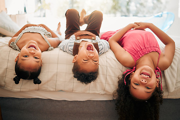 Image showing Silly kids playing upside down on bed enjoy and having fun together in parents bedroom. Happy children or siblings bonding and enjoying childhood together at cozy, warm and comfortable family home