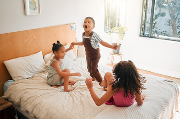 Image showing Children, fun and energy by playing siblings jumping, bonding and enjoying a game on bed at home together. Kids laughing and having fun, sharing playful moments of childhood, celebrate free weekend