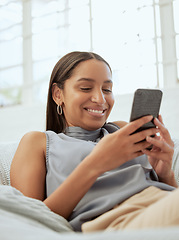 Image showing Happy, relaxed and modern woman with a phone texting, checking social media app or reading message online while relaxing on sofa indoors at home. Casual female browsing the internet for funny content