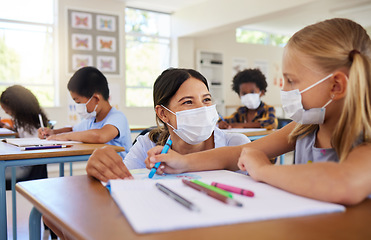 Image showing Covid, education and learning with a teacher helping a student during class at school with classmates in the background. Female educator wearing a mask and assisting a girl child with her study work