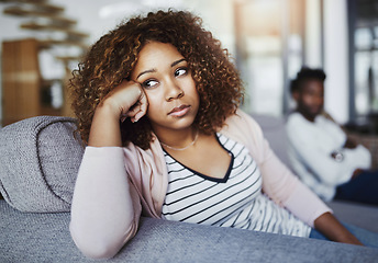 Image showing Relationship issues, communication problems and divorce talk of a couple after a fight at home. Upset female feeling frustrated on a living room couch. Annoyed couple on a sitting on a sofa