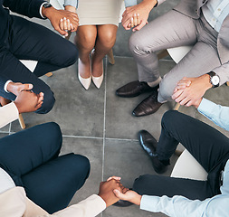 Image showing Support, teamwork and unity of business group holding hands and sitting in a circle doing a team building plan. People, team or diverse employees united in trust during a meeting in an office