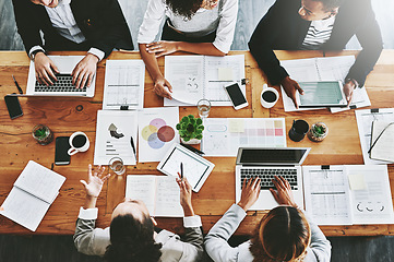 Image showing Overhead of colleagues having a marketing meeting in modern office. Above a busy workplace, coworkers brainstorm and develop strategies for a startup business, unity, planning and innovation at work