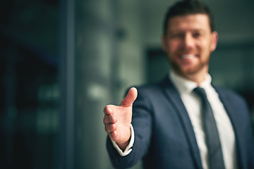 Image showing Professional corporate businessman about to give a handshake as a greeting or agreement after negotiations on a deal, partnership or merger. Executive male offering formal gesture at business meeting