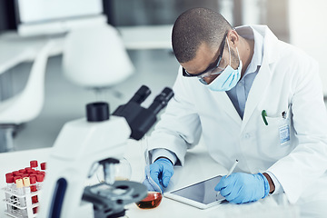 Image showing Scientist, researcher and medical worker using a tablet for innovation and research while wearing a face mask in a lab. Male chemist working to find a cure for covid virus in a science facility