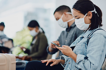 Image showing Female tourist on phone traveling during covid at airport waiting for departure, wearing a mask for protection. For hygiene and healthcare security, follow corona virus social distance regulations.