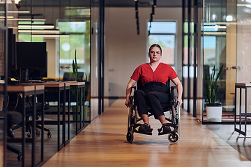 Image showing A modern young businesswoman in a wheelchair is surrounded by an inclusive workspace with glass-walled offices, embodying determination and innovation in the business world