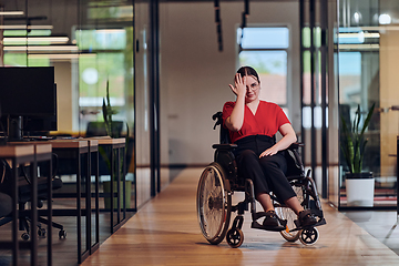 Image showing A modern young businesswoman in a wheelchair is surrounded by an inclusive workspace with glass-walled offices, embodying determination and innovation in the business world