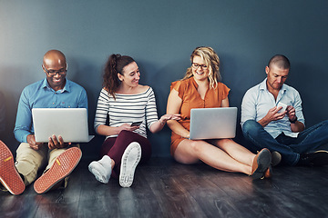 Image showing Smiling, diverse group of casual and modern business people with their digital devices on social media networking apps. Happy, connected team of colleagues sitting, working on laptop pcs and phones