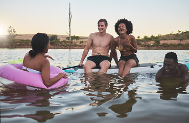 Image showing Laughing friends, swimming and playful bonding on summer break with pool inflatable tube in lake, ocean or sea. Diverse group of men or women having fun together and being social on holiday at sunset