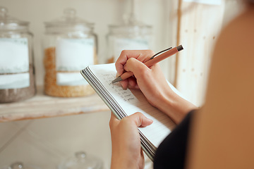 Image showing Entrepreneur stock counting and writing or planning shopping list in a store on a notepad. Small business owner making a budget for inventory and restocking of supplies in local store, shop or cafe