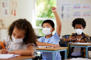 Image showing School student raising hand to volunteer, participate and answer question at class lesson in covid pandemic. Curious, smart and clever young boy wearing a mask for education and learning