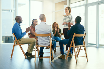 Image showing Business woman coaching a teamwork seminar at work about job motivation and success. Group of office workers clapping hands after a team presentation. Smiling colleagues sitting together in a meeting