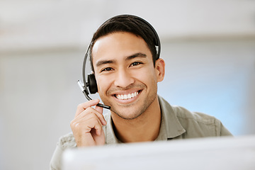 Image showing Smiling, friendly call center agent with headset for online consulting in an IT tech agency. Face of male ecommerce support professional offering virtual assistance to web user or contact us hotline