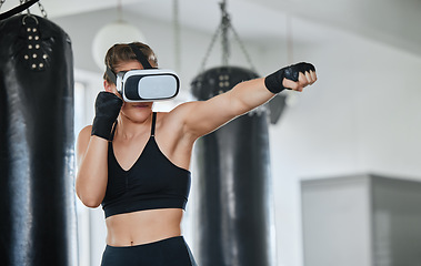 Image showing Healthy, fit and active boxing woman with a VR headset to access the metaverse while exercising, training and working out in a gym. Female boxer doing a workout in virtual reality with technology.