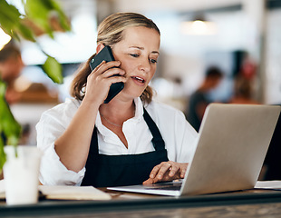 Image showing Coffee shop owner on a phone call while working online on her laptop inside a local cafe store. Contact us, learn about us and talk to our baristas, managers and small startup business entrepreneurs