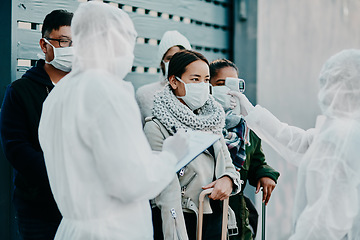 Image showing Travel healthcare worker testing covid temperature outside with an infrared thermometer. Medical professional doing a coronavirus check on people at an entrance to prevent the spread of the virus