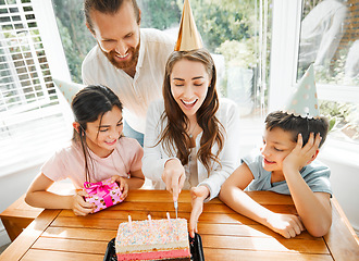 Image showing Birthday, cake and celebration with a family celebrating a mother on a special day. Cutting the dessert, having a party and spending time together. Fun, laughter and enjoyment with mom, dad and kids