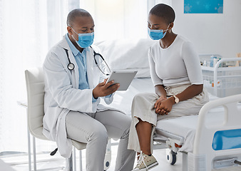 Image showing A doctor consulting a patient and talking to her about the covid virus using a tablet at the hospital or clinic. Female at her appointment or consultation with a healthcare or medical worker