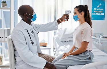 Image showing Temperature, thermometer and covid routine with doctor, medical professional and healthcare worker in clinic, hospital or wellness center. Woman or patient with mask checking fever to prevent disease