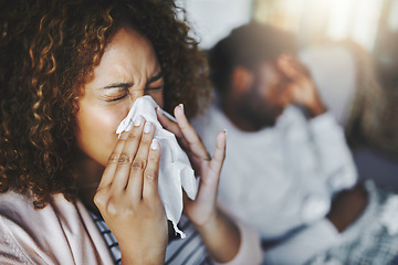 Image showing Ill or sick woman with allergy, sinus infection sneezing in tissue or blowing nose during flu season at home. Sick girl caught a bad cold showing symptoms of covid, or suffering from a virus disease