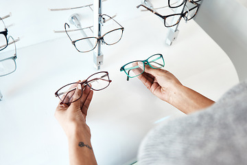 Image showing Buying, looking and shopping for glasses at a retail eyewear store and optometrist inside. Customer holding shop stock trying to decide on a new modern style, trendy and stylish frames to buy on sale