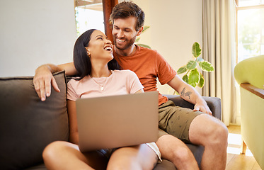 Image showing Couple talking and browsing on a laptop while relaxing on a sofa at home. Girlfriend and boyfriend scrolling on social media or the internet with technology while having conversation in living room.