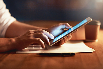 Image showing Closeup of a persons hands holding and scrolling on a digital tablet planning late in the evening at night. Modern man working online with a touchscreen display device, at desk of workplace