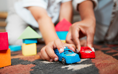 Image showing Closeup hands playing with fun toys, cars and building blocks in a home living room. Parent bonding, having fun and enjoying family time with a playful, small and little child during childhood fun