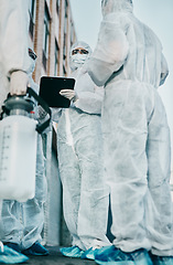 Image showing Healthcare workers outside in protective gear during an outbreak in the city. A group of scientists wearing hazmat suits, cleaning urban areas. Safety staff in coveralls due to covid health risks.