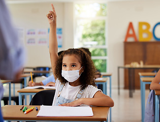 Image showing Covid, learning and education with a young girl student wearing a mask and raising her hand to ask or answer a question in class at school. Female child asking or answering the teacher in a classroom