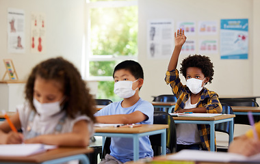 Image showing Covid, students and education children in school classroom raising hand to answer, ask or question lesson with classmates. Diverse group of kids, boys or girls with face masks learning in study class